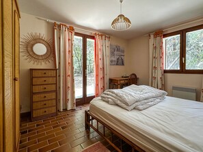A bedroom with a bed, dresser, desk, and a view of the outdoors. - Spacious villa for 10 guests - Park - Wi-Fi, Air Conditioning (La Palmyre)