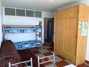 A dormitory room with bunk beds, a wardrobe, and a map on the wall. - Ground Floor Studio Sea View - Saint-Jean-de-Monts (Saint-Jean-de-Monts)