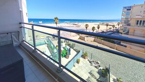 Un balcon avec vue sur une plage et l’océan.