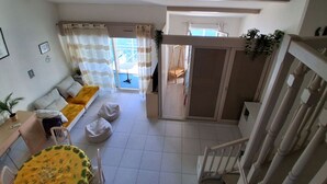 Un vaste espace de vie comprenant un canapé, une table à manger et un escalier.