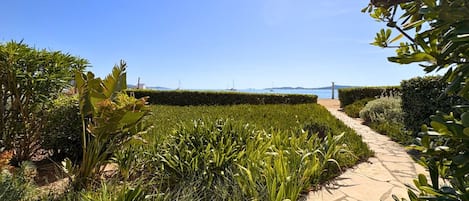 Un jardin aménagé avec un sentier menant à un point de vue sur la mer.