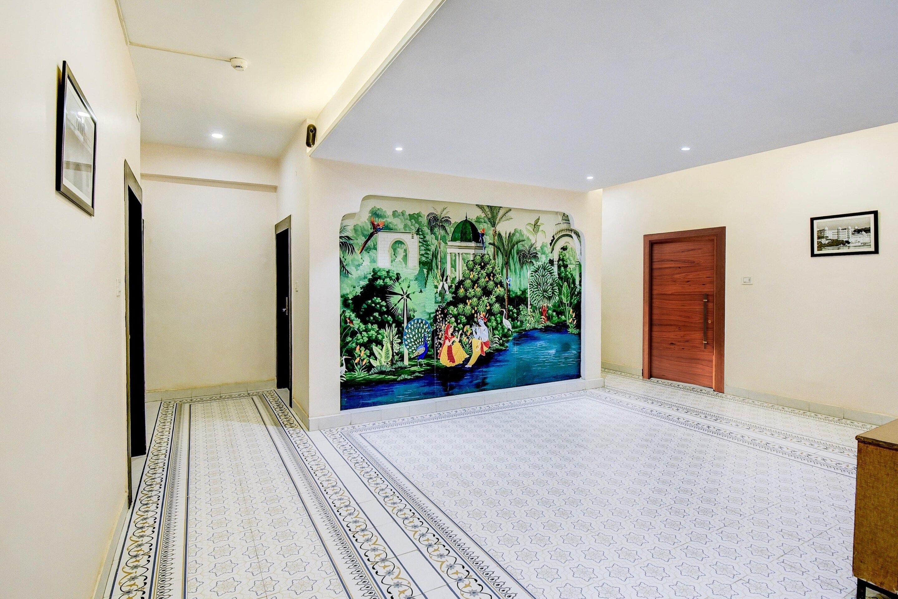 Corredor com um mural de paisagem tropical, porta de madeira e piso estampado.