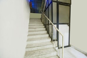 Eine Treppe mit Geländer und einer Tür am Fuß.