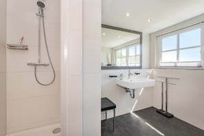 A modern bathroom with a shower, sink, and a small stool. - Luxurious thatched house in Zinnowitz - wellness, garden & fireplace (Zinnowitz)