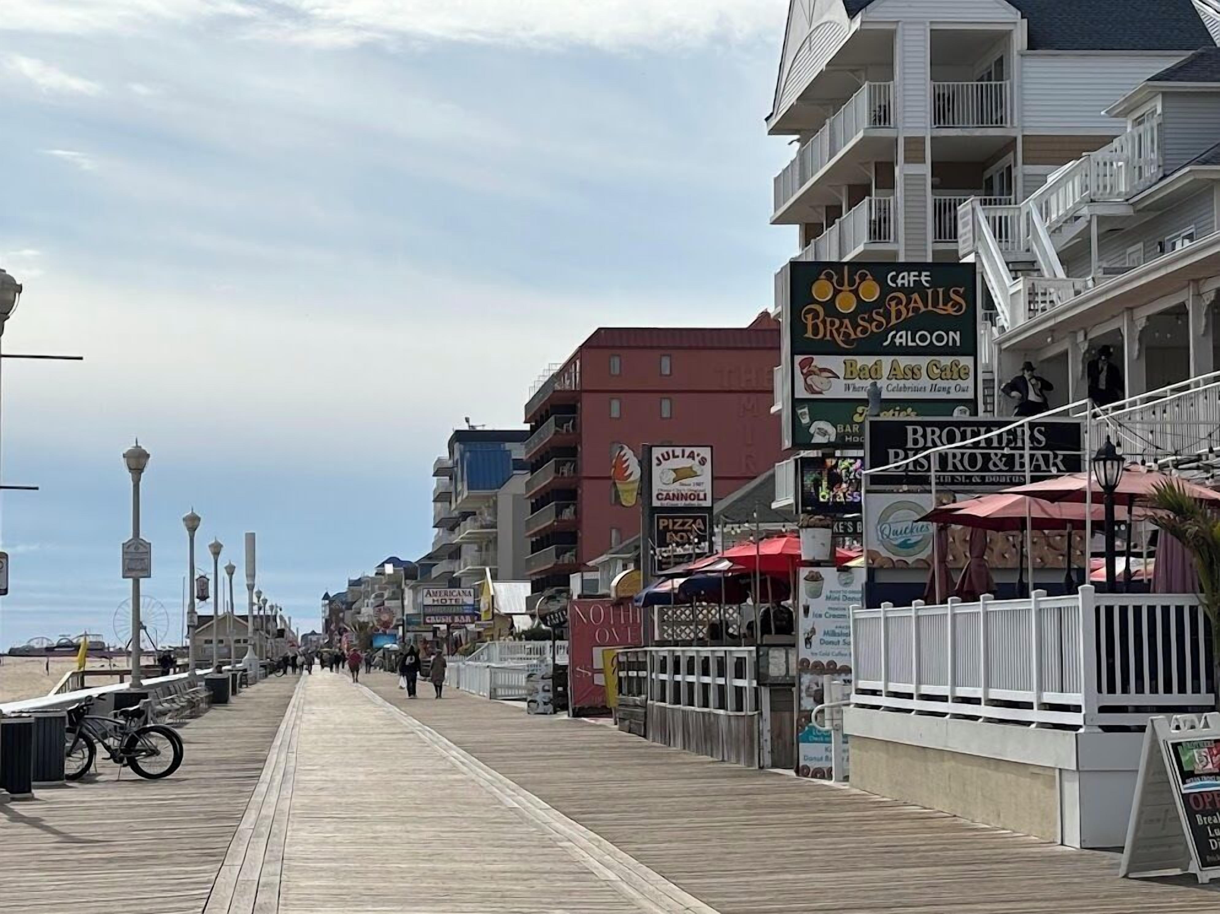 Une promenade en bord de mer bordée de diverses boutiques et de restaurants, notamment un café et une pizzeria.
