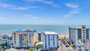 A coastal hotel with multiple floors, a beach view, and a parking area. - Beautiful 1 bedroom oceanfront condo, free WiFi, linens included and an indoor pool located right on the boardwalk! (Ocean City)