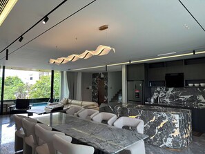 A modern kitchen with a marble countertop, a built-in oven, and a large island with seating. - SONG CAT VILLA 53DP8 - Beautiful 7-bedroom villa with AC in marvelous Da Nang (Da Nang)