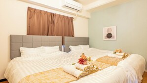 A hotel room with a large bed, a grey headboard, and a brown curtain. There is an air conditioning unit on the wall and a framed picture on the wall. - Akitsu 703 Kyocera Dome 10 min walk Dotonbori Kansai Airport Osaka Castle Kaiyukan USJ 1 transfer Family friendly Free parking 15 (大阪府大阪市西区境川１丁目)