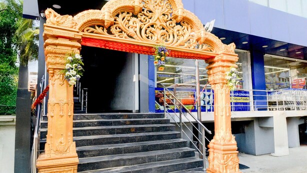 A grand entrance with ornate golden pillars and a staircase leading up to a building. - Super Hotel O Kota Railway Junction (Kota)
