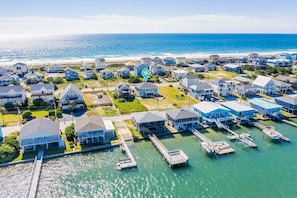 An aerial view of a coastal residential area with houses, docks, and a marina. - Charming 3 bedroom house with views of the ocean and the sound (Topsail Beach)