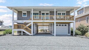 Et tosset hus med en overdækket veranda, garage og indkørsel.