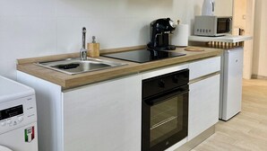 Una cocina moderna con horno empotrado, cafetera y microondas.