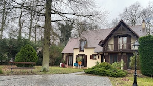 A traditional house with a stone pathway leading to the entrance, surrounded by trees and a bench. - Cozy 1-bedroom house in amazing Villebon sur Yvette with AC (Villebon sur Yvette)