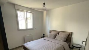 A bedroom with a bed, a window, and a ceiling fan. - Atypical town house (Saint-Mariens)