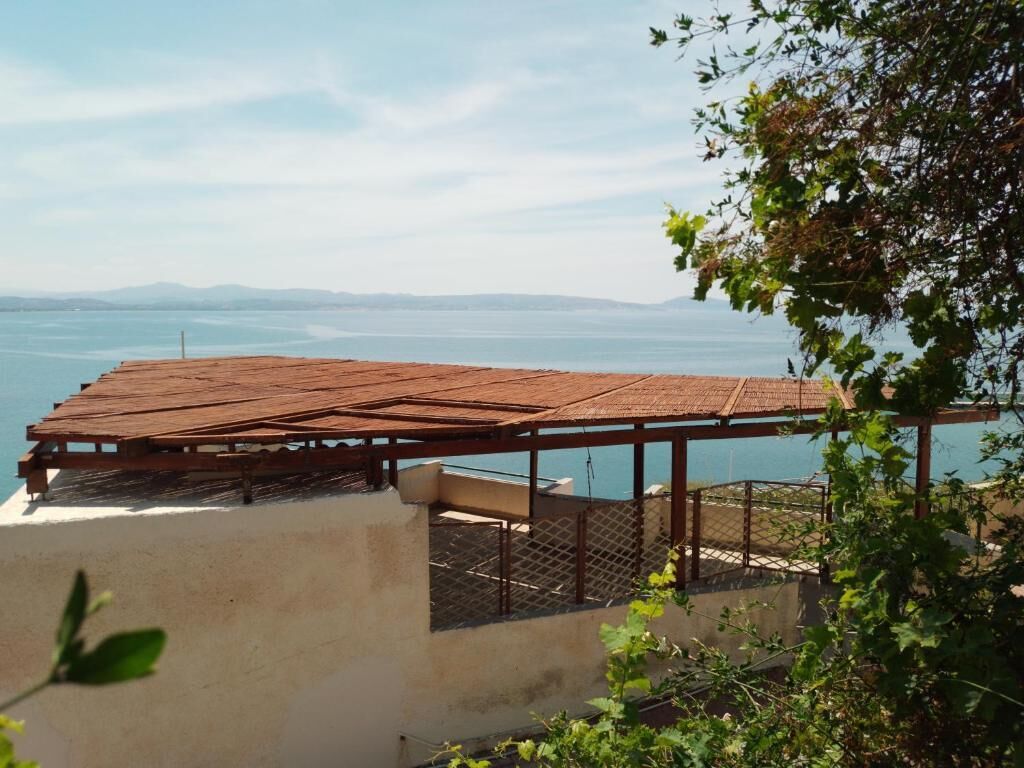 Terraza de madera con vistas a un cuerpo de agua y montañas a lo lejos.