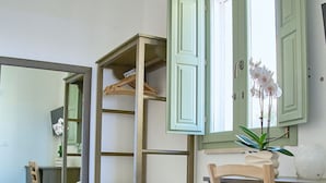Une chambre à coucher avec un lit, une chaise en bois, un bureau et une armoire.