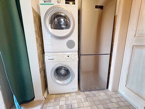 A compact laundry room with a front-loading washing machine and a built-in dryer. - Schwarzwaldhof mit Pool & Sauna by Interhome (Görwihl)