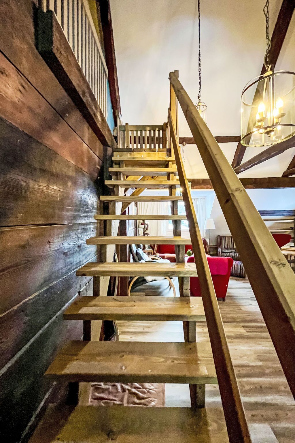 Un escalier en bois, doté d’une rampe, mène à un niveau supérieur.