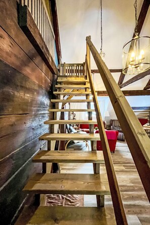 Un escalier en bois, doté d’une rampe, mène à un niveau supérieur.