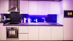 A modern kitchen with white cabinets, a stainless steel range hood, a built-in oven, and a sink with a faucet. - Munich Finest Apartments Studio 1 by Interhome (Munich)