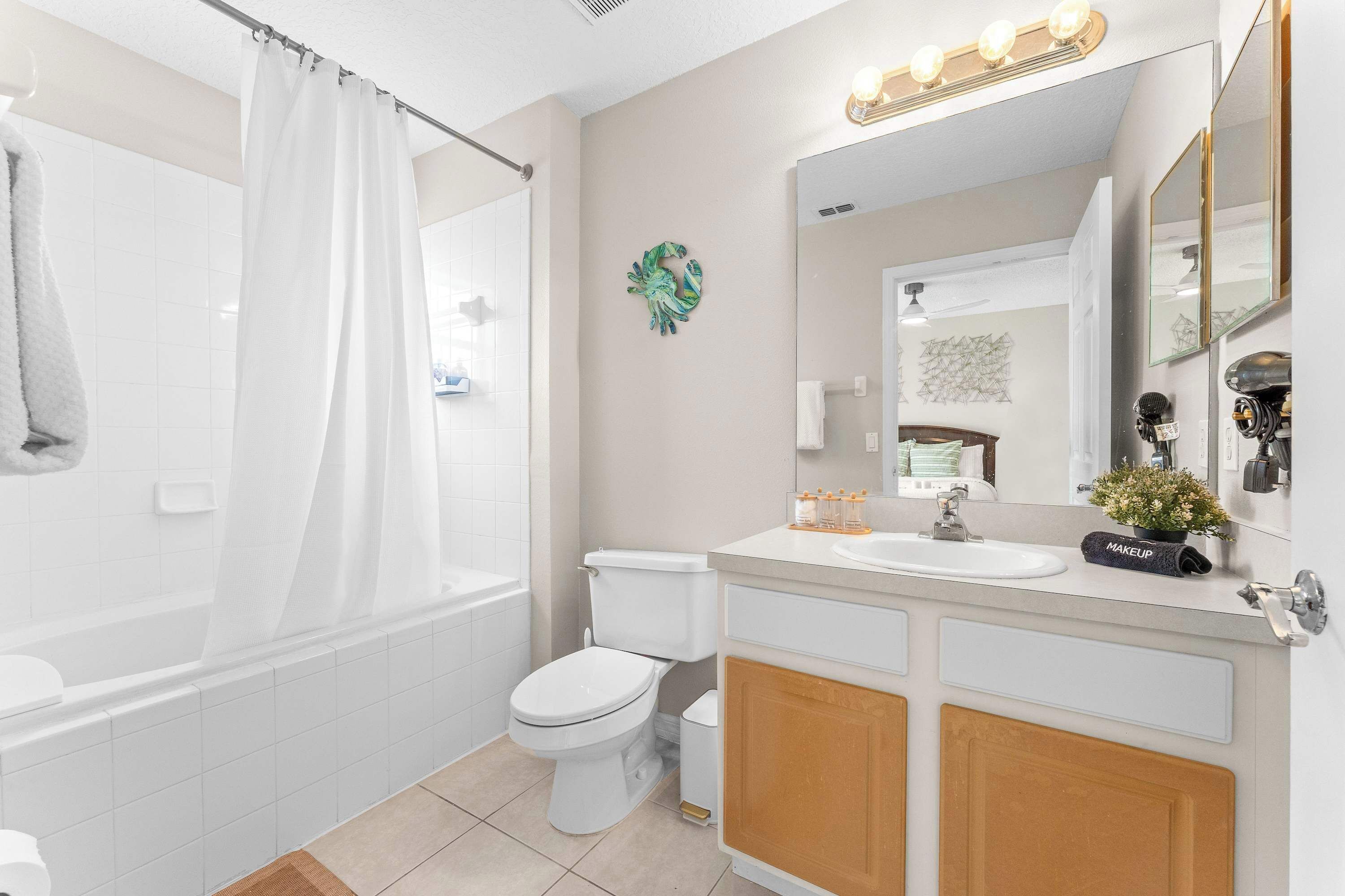 Un baño moderno con bañera, inodoro y tocador con espejo y lavabo.