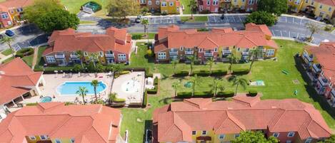 A residential complex with multiple apartment buildings, a central courtyard with a swimming pool, and a parking area.