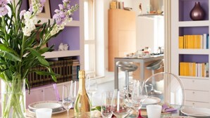 Ein Esstisch, gedeckt mit Tellern, Gläsern und einer Champagnerflasche.