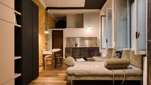 A modern living room with a sofa, a dining area, and a kitchen. - Hostmate - Milano - Pontaccio - Brera (Milano)