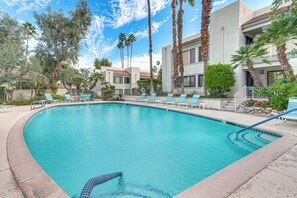 A swimming pool with lounge chairs, surrounded by palm trees and a building with balconies. - 2 Mi to Dtwn Palm Springs! Modern Condo w/ Pool (Palm Springs)