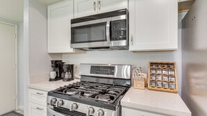 A kitchen with a stainless steel stove, a microwave, and a coffee maker. - 2 Mi to Dtwn Palm Springs! Modern Condo w/ Pool (Palm Springs)