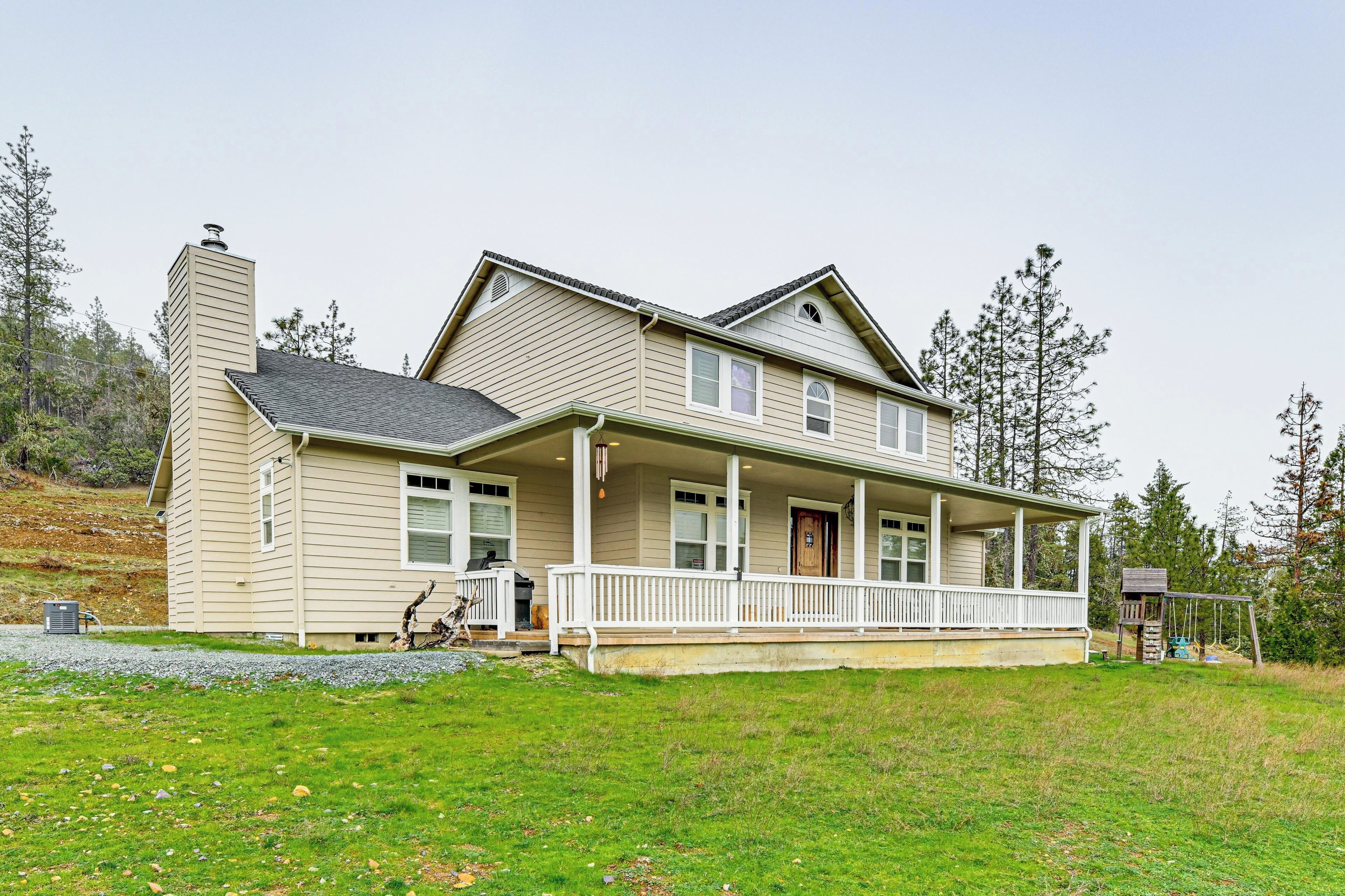 A two-story house with a front porch, a chimney, and a small attached garage.
