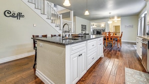 A spacious kitchen with a large island, wooden flooring, and pendant lighting. - Limpy Creek Access! Family Retreat in Grants Pass (Grants Pass)