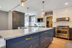 A modern kitchen with a large island, stainless steel appliances, and pendant lighting. - Explore Orange & Nyc! Luxury Family Home w/ Deck (Orange)