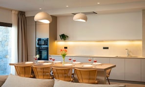 Une cuisine moderne avec un coin repas, équipée d’un four à micro-ondes, d’un four traditionnel et d’un évier.