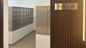 Corredor com caixa de correio e abertura para correspondência na parede.