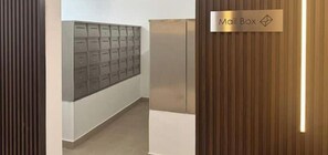 Un pasillo con un buzón y un ranurero de correo en la pared.