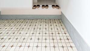 A hallway with a patterned floor and a door at the end.