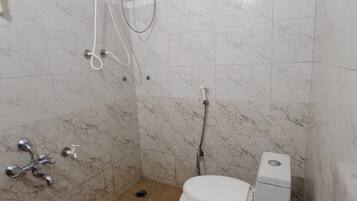 A bathroom with a toilet, a shower, and a water heater.