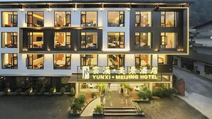 A modern hotel with multiple floors, large windows, and a well-lit entrance. - Zhangjiajie Yunxi Scenic Hotel (Zhangjiajie)
