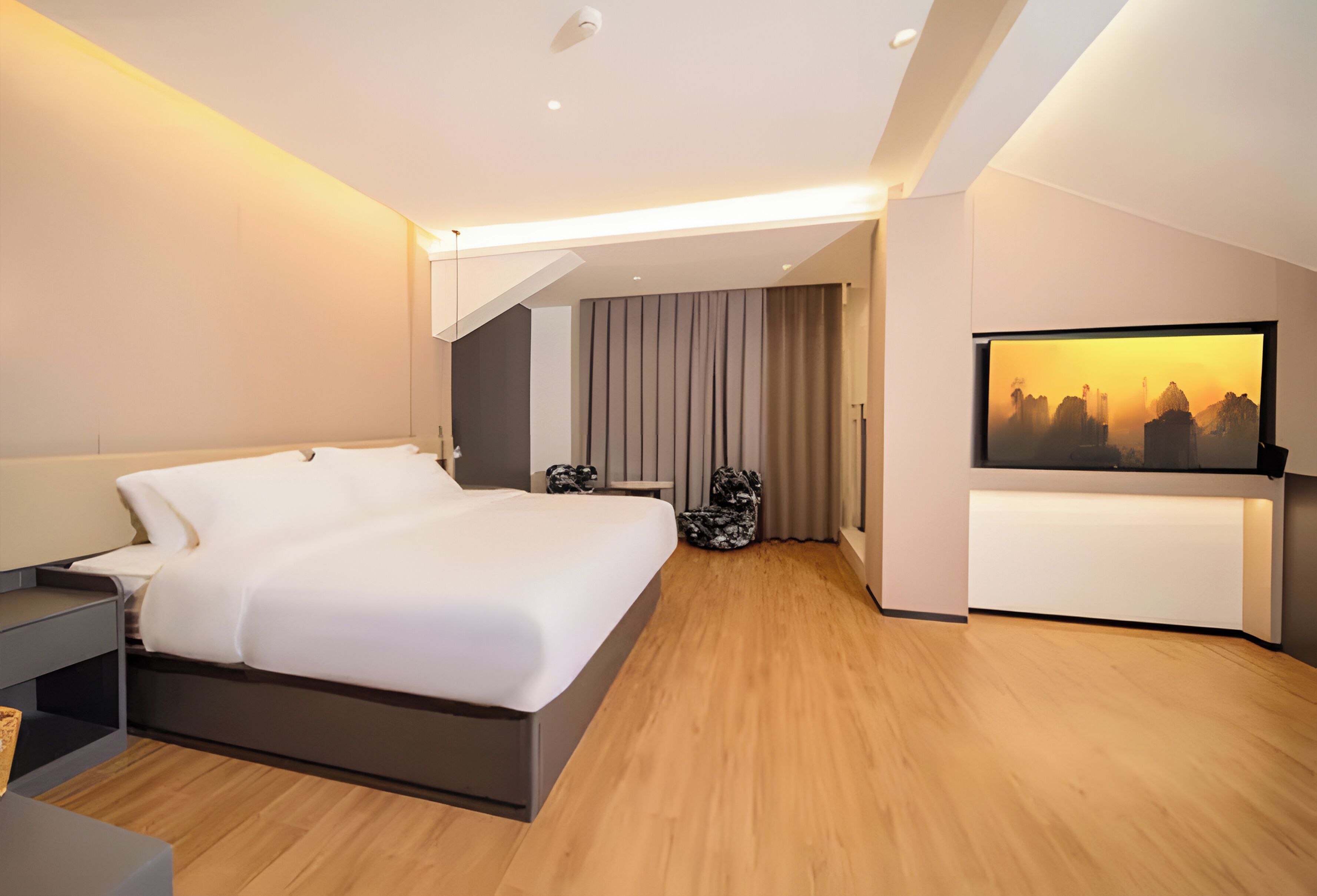 A modern hotel room with a large bed, a flat-screen TV, and a cityscape view.