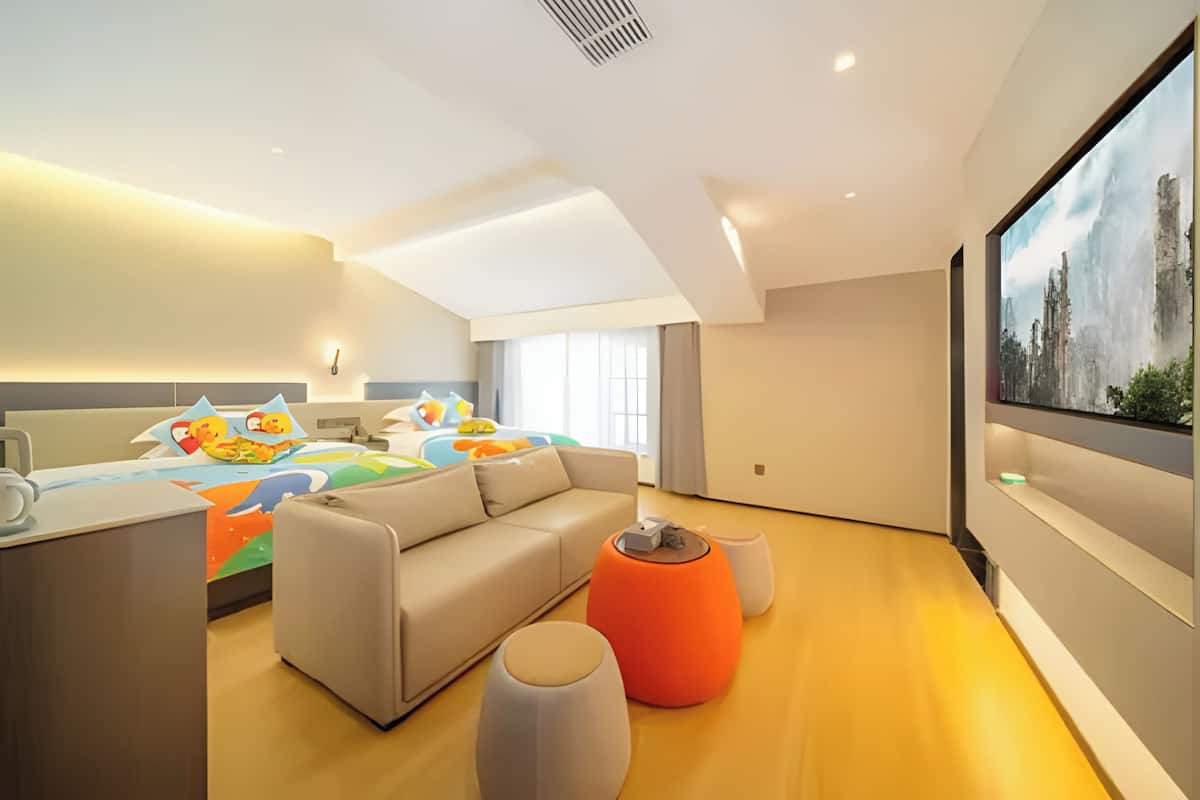 A modern bedroom with a large bed, a sofa, and a TV.