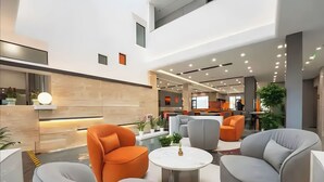 A modern lobby with a pool, seating areas, and a reception desk. - Zhangjiajie Yunxi Scenic Hotel (Zhangjiajie)