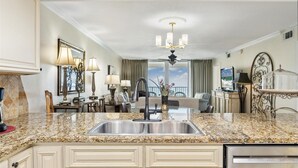 A modern kitchen with granite countertops, a stainless steel sink, and a built-in dishwasher. - Shoreline Towers 2075 2 Bedroom Condo (Destin)