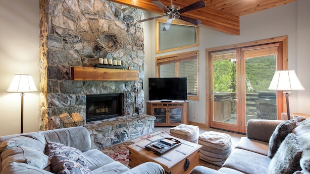A cozy living room with a stone fireplace, a flat-screen TV, and comfortable seating. - 503 - Four Bedroom with Spa Trail's End Lodge 4 Condo (Park City)