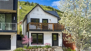 A two-story house with a balcony, a garage, and a well-maintained garden with rocks and flowering plants. - Pet Friendly! Elevation 25 2 Bedroom Home (Park City)