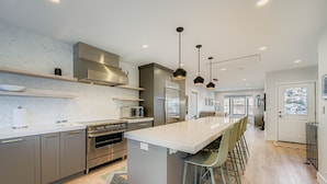 A modern kitchen with a central island, stainless steel appliances, and pendant lighting. - Pet Friendly! Elevation 25 2 Bedroom Home (Park City)