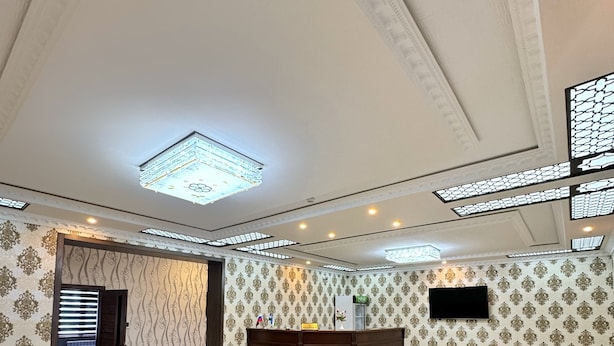 A spacious lobby with a reception desk, a dining area, and a seating area with a decorative coffee table.
