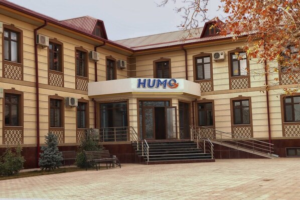 A building with a sign reading "HUMO" and a staircase leading to the entrance.