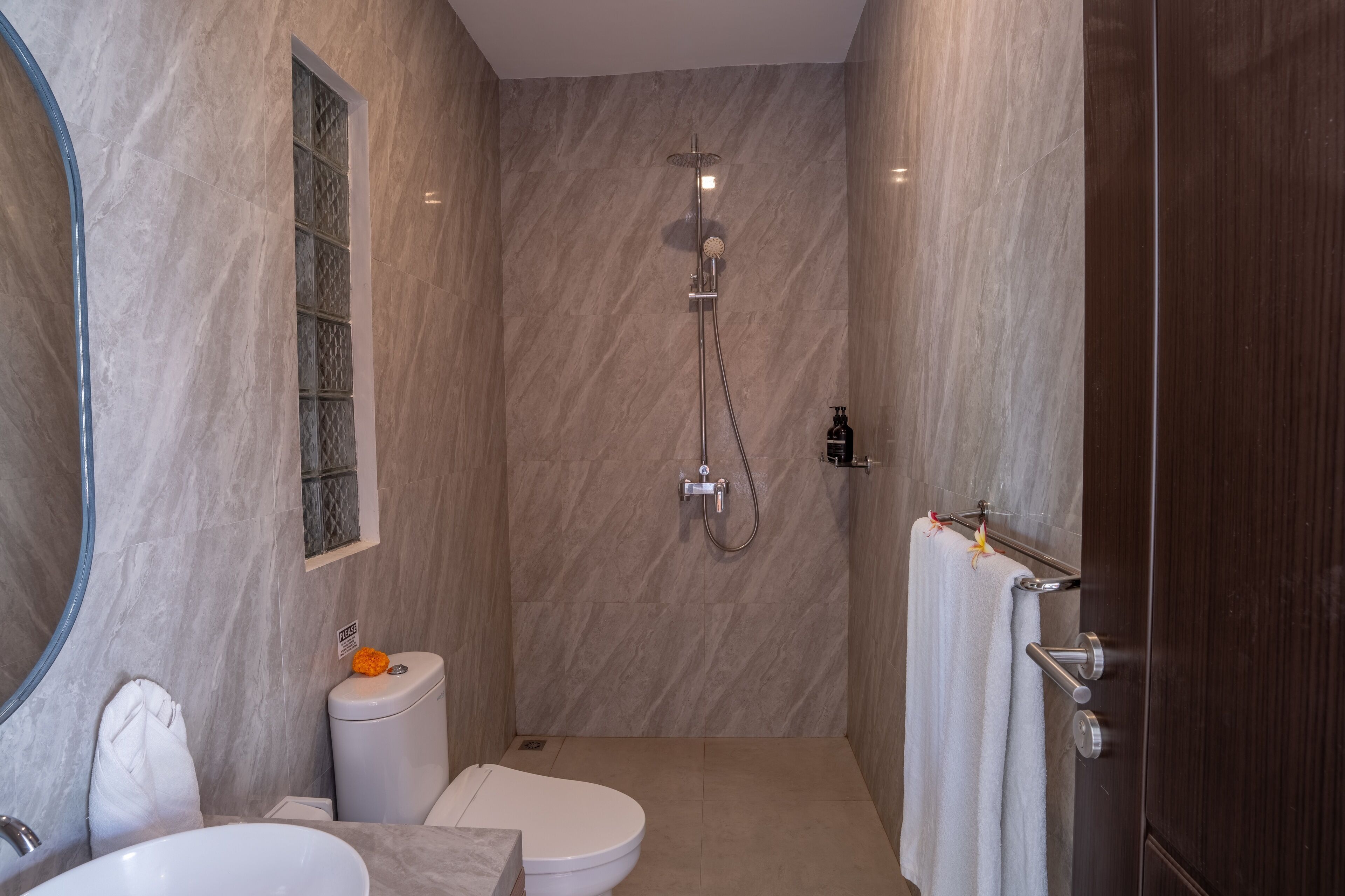 A modern bathroom with a toilet, sink, and shower.