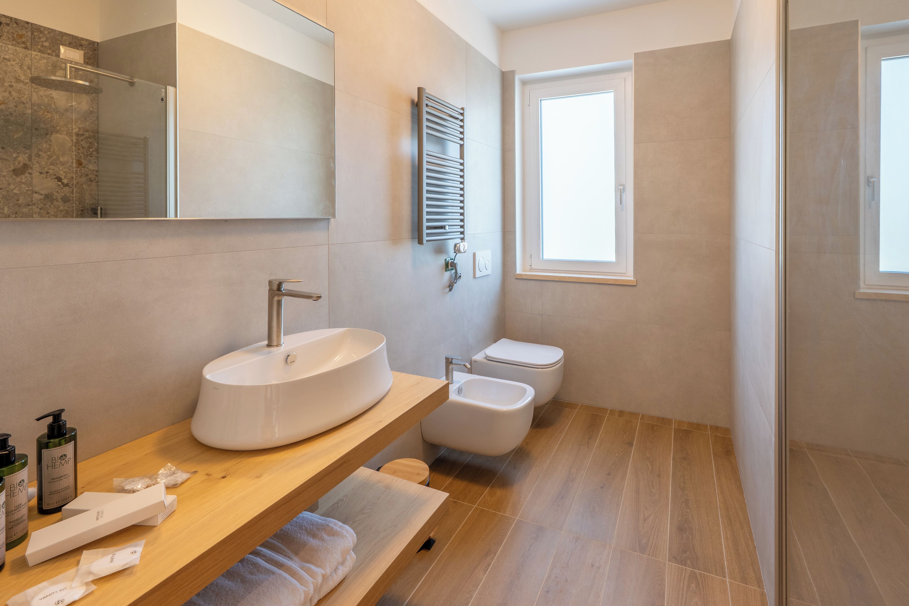 Un baño moderno con un lavamanos grande, un bidé y un inodoro.